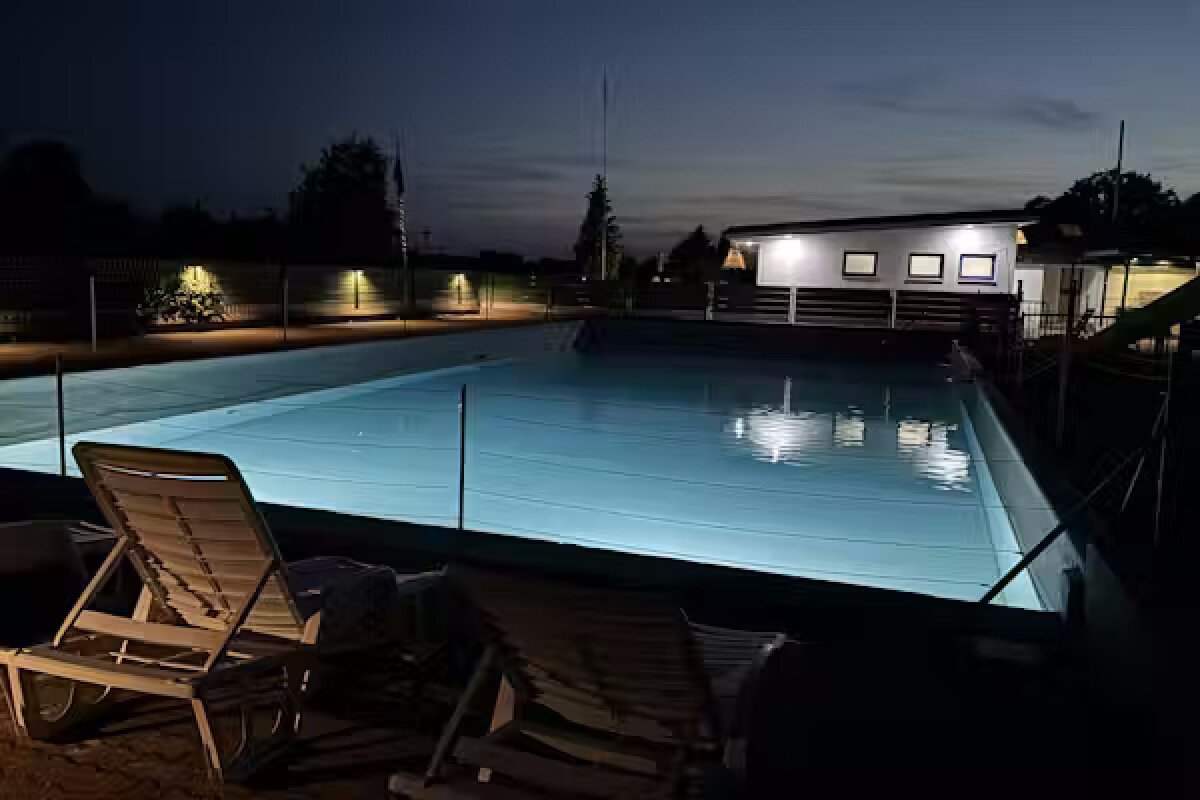Camping-Paradies-Gruener-Jaeger-Blick-auf-den-beleuchteten-Pool-bei-nach-Einbruch-der-Dunkelheit-407c8b42-d637-4a5e-b1a4-ded6aa0f4488