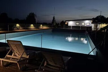 Camping-Paradies-Gruener-Jaeger-Blick-auf-den-beleuchteten-Pool-bei-nach-Einbruch-der-Dunkelheit-407c8b42-d637-4a5e-b1a4-ded6aa0f4488