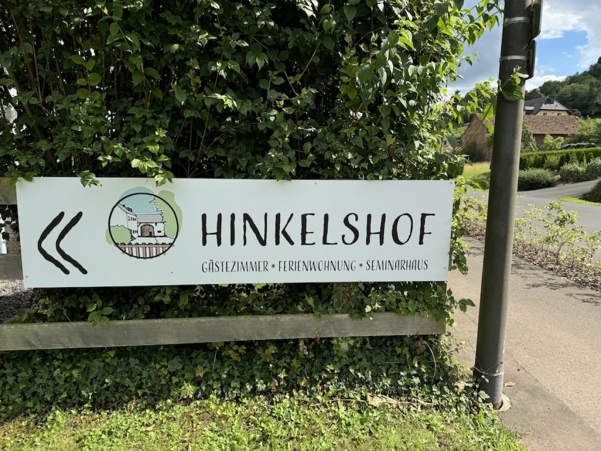 Schild Parkplatz -> Eingang Campingwiese durch das große Holztor auf dem Parkplatz